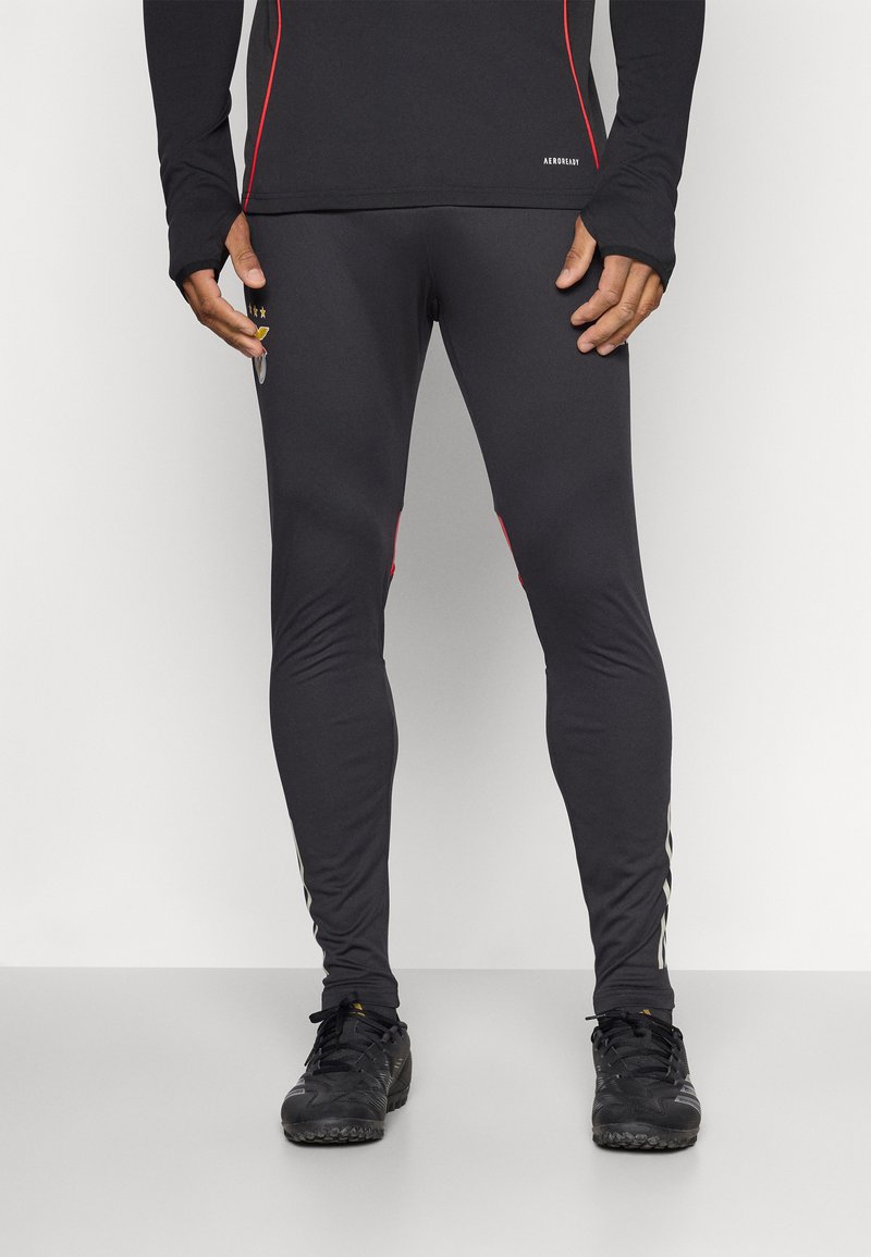 Zwarte sportleggingen met rode zijkanten, gemaakt van rekbaar materiaal, met een aansluitend ontwerp voor comfort en flexibiliteit.