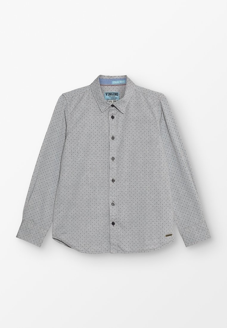 Chemise grise à manches longues avec un col boutonné, présentant un motif de petits points noirs. Comprend des boutons noirs et une étiquette de marque à l'ourlet.