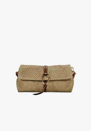 Bolso de mano de paja trenzada con solapa doblada, correa de cuero marrón, hebilla dorada y correa lateral desmontable sobre fondo blanco.