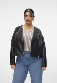 Jacket din piele ecologică neagră cu un design scurt, fermoar asimetric și mâneci lungi. Pur tată peste un top lătăc cu dungi de culoare deschisă, asortat cu blugi albaștri.