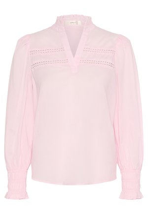 Helle rosa Bluse mit Rüschkragen, geteilt am Ausschnitt und filigranen Lochstickereien über der Brust; lange Puffärmel mit gerafften Manschetten.