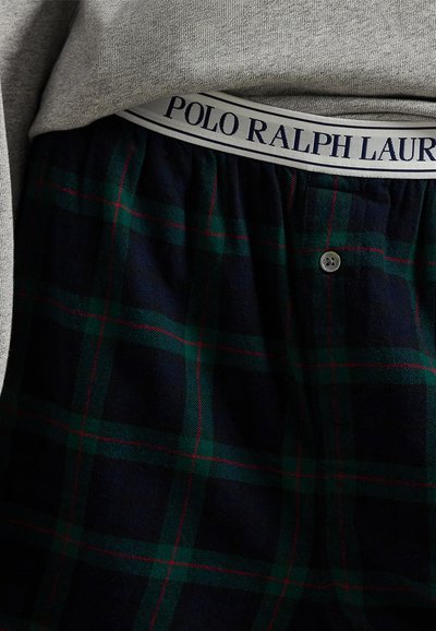 Grå sweatshirt ovanpå marinblå rutiga kalsonger, med gröna och röda linjer, med en vit elastisk midjeband märkt "POLO RALPH LAUREN."