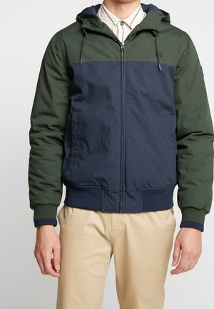 Hættebombejakke med farveblokdesign i mørkegrøn og marineblå, lavet af glat stof med ribbet manchetter og kant.