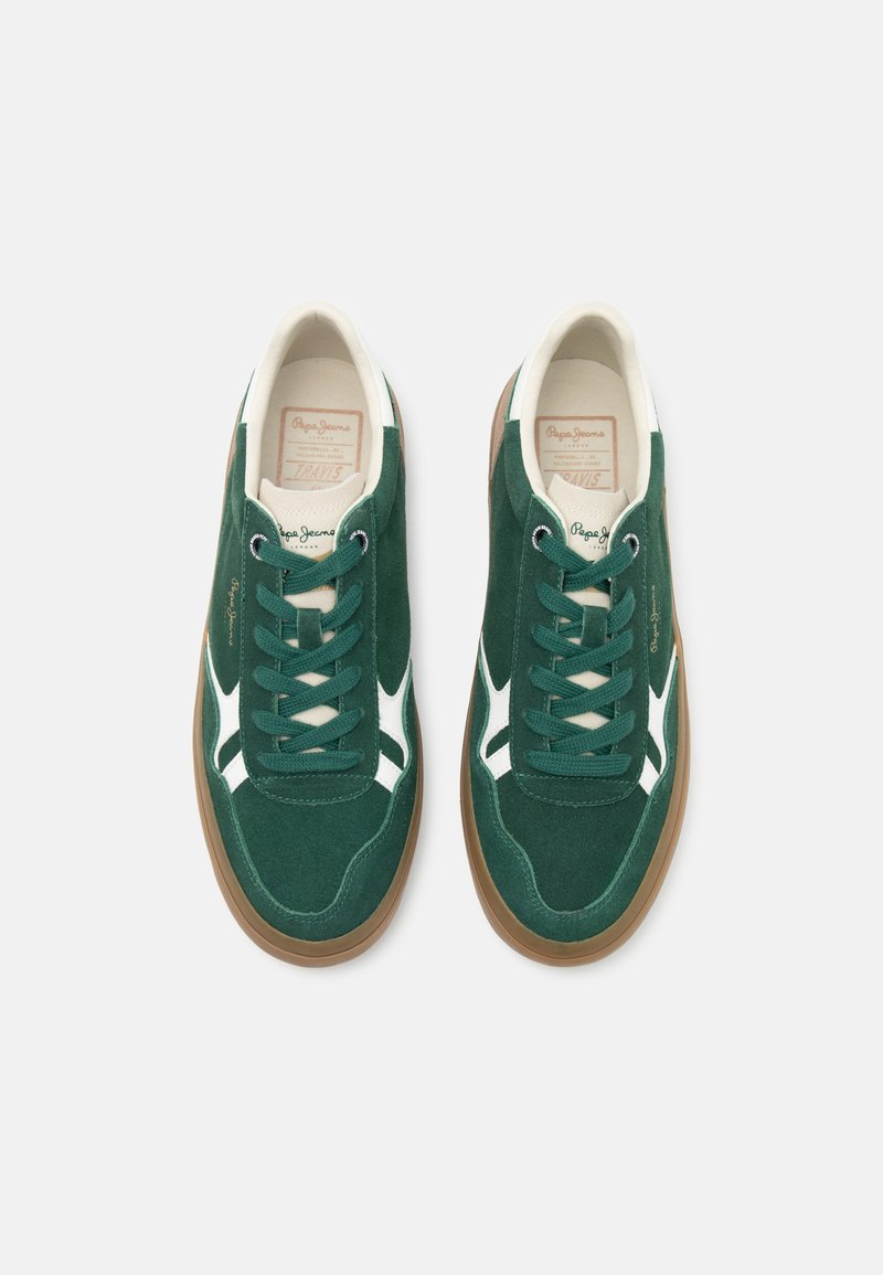 Baskets en daim vert avec des accents blancs, dotées d'une semelle en gomme, de lacets ronds et d'une étiquette de langue de marque. Textures lisses et design sportif.