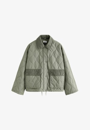 Vihreä tilkkutakkia, jossa on corduroy-kaulus ja kaksi suurta etutaskua. Varustettu nepparilla ja rennolla leikkauksella, näkyvien ompelukuviot.