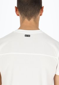 Hvid kortærmet atletisk t-shirt med et tekstureret, letvægtsmateriale, rund halsudskæring og STX Quick Dry mærke på bagsiden.
