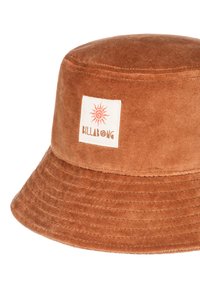 Smešani šešir od smešnog baršuna u smešnoj smeđoj boji sa ravnim vrhom i širokim obodom. Ima beli etiket sa grafikom sunca i imenom brenda "BILLABONG."