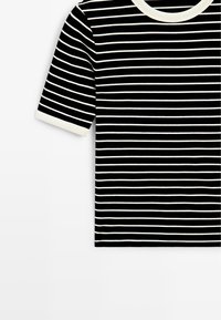 Schwarzes Kurzarmhemd mit weißen horizontalen Streifen und weißem Rundhalsausschnitt sowie weißem Ärmelbündchen, dargestellt vor einem weißen Hintergrund.