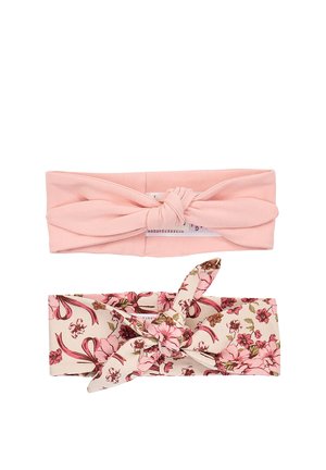 Twee stoffen haarbanden, één effen lichtroze met een knoop, de andere crème met roze bloemenprint en een gedraaide knoop, afgebeeld op een witte achtergrond.