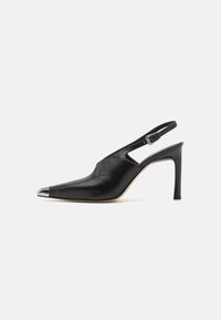 Juodi odiniai slingback aukštakulniai su smailiu pirštu ir metaliniais apvadais. Yra išpjovos dizainas ir liekna aukšta pakulnė.