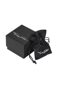 Scatola di gioielli nera Thomas Sabo e sacchetto nero con cordoncino e logo bianco su sfondo bianco.