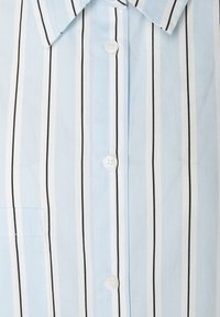 Light blue button-up shirt with white and black vertical stripes, featuring a pointed collar and a chest pocket. Smooth cotton texture.