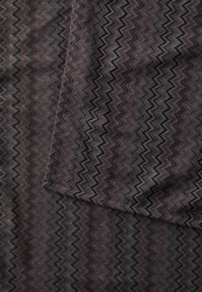 Woven fabric in dark gray with a zigzag pattern in varying tones. Textured surface with subtle sheen, showcasing a complex design.