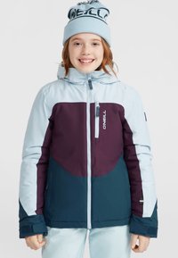Veste isolante bleu et violet avec une capuche, dotée d'une fermeture éclair à l'avant et de poignets élastiques. Accompagnée d'un bonnet en tricot bleu clair.