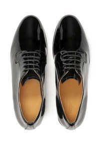 Scarpe oxford in vernice nera con una finitura liscia, design con lacci e solette marrone chiaro. Punta arrotondata con una sottile cucitura decorativa.