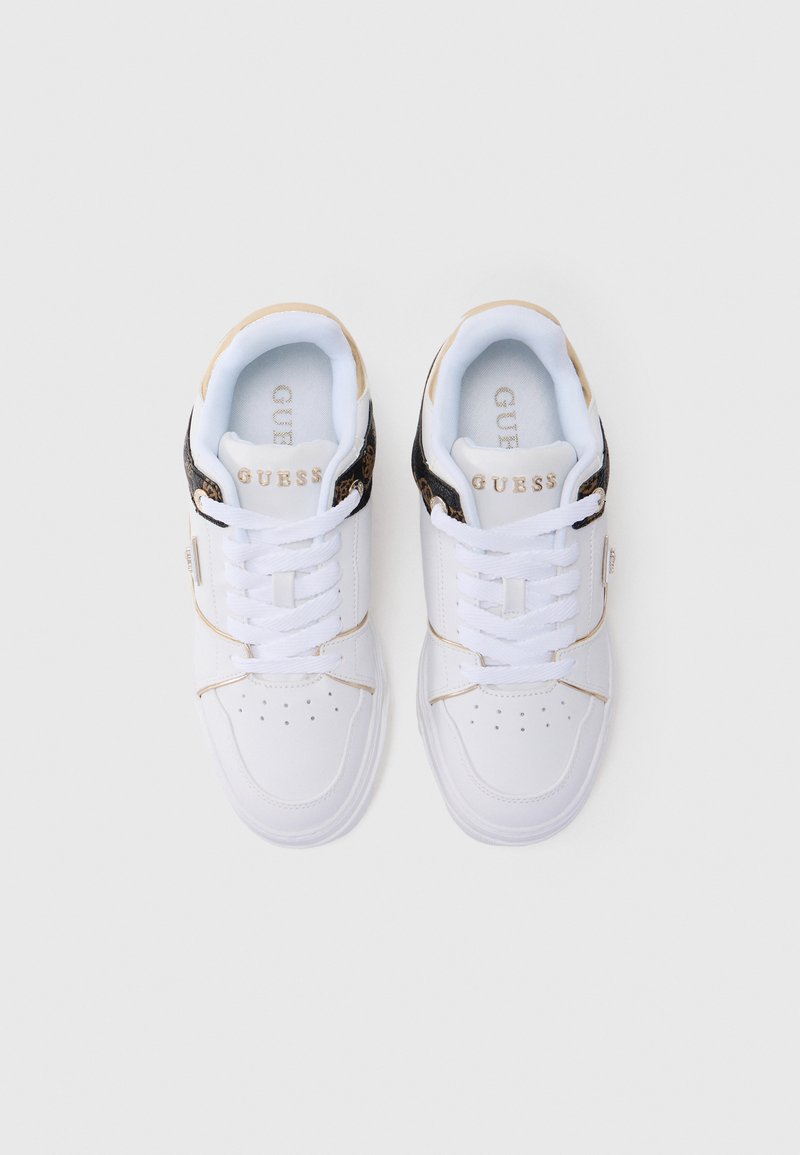Een paar witte Guess sneakers met witte veters, gouden accenten en zwart luipaardprintdetail op de hielkraag, bekeken van bovenaf.