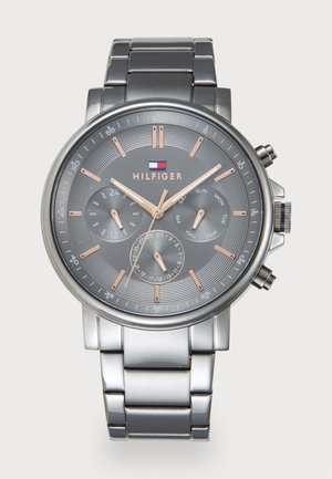 Montre en métal argenté avec un cadran texturé gris, des accents en or rose, trois sous-cadrans et un bracelet en acier inoxydable. Présente un design chronographe.
