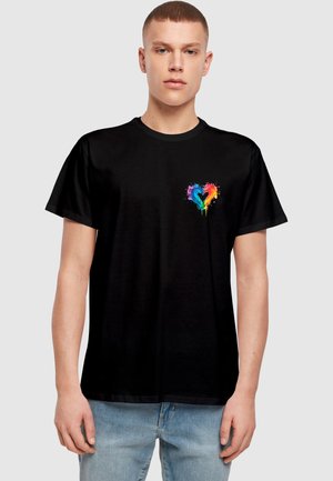 Black cotton t-shirt featuring a colorful, splattered heart design on the chest. Relaxed fit with short sleeves and a crew neck.