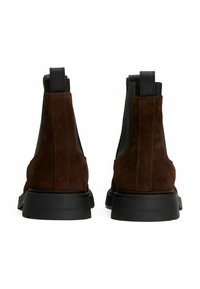Stivali Chelsea in camoscio marrone con pannelli laterali elasticizzati, accenti neri testurizzati e una suola in gomma resistente, caratterizzati da un marchio impresso sul tallone.