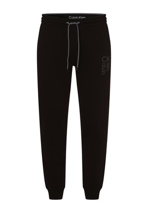 Pantalon de jogging noir Calvin Klein avec taille à cordon et chevilles élastiquées, avec un subtil logo vertical sur la cuisse droite.
