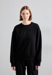 Μαύρη φούτερ μπλούζα με ανάγλυφο λογότυπο "EA7 Emporio Armani" στο κέντρο, σε άνετη γραμμή με ραμμένα μανίκια και τελείωμα.