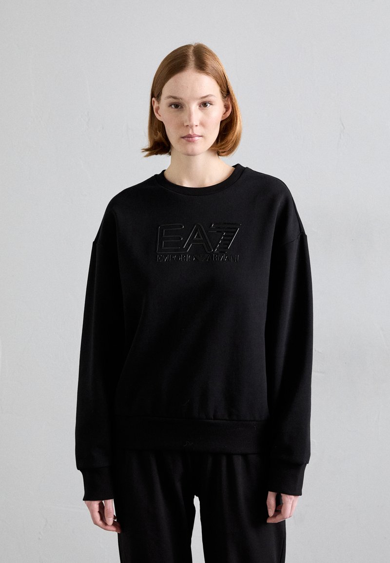 Μαύρη φούτερ μπλούζα με ανάγλυφο λογότυπο "EA7 Emporio Armani" στο κέντρο, σε άνετη γραμμή με ραμμένα μανίκια και τελείωμα.