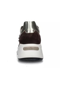 Sneaker in suede marrone con un tallone metallico argento e suola bianca che presenta il marchio “NeroGiardini”. Suola testurizzata per una buona aderenza.