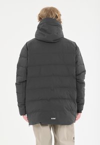 Puffig mörkgrå jacka med huva, med horisontell kviltad design, elastiska ärmslut och en logotyppatch på den nedre ryggen.