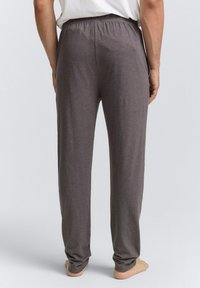 Pantalons de lounge gris avec une taille élastique, offrant une coupe décontractée, une texture douce et des jambes droites, conçus pour le confort.