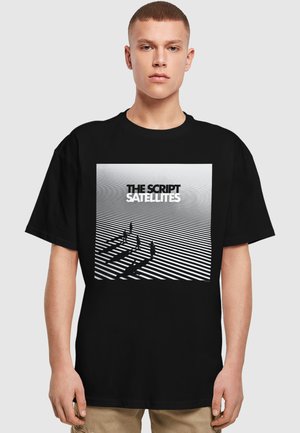 Sort T-shirt med grafisk tryk af fem figurer, der kaster skygger på horisontale striber, med teksten "THE SCRIPT SATELLITES" ovenfor.