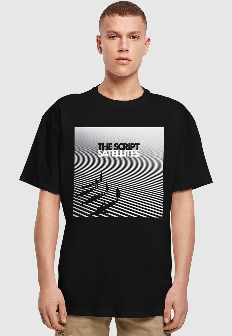 Sort T-shirt med grafisk tryk af fem figurer, der kaster skygger på horisontale striber, med teksten "THE SCRIPT SATELLITES" ovenfor.