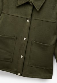 Olivgrüne Wildlederjacke mit spitzem Kragen, zwei Fronttaschen und Druckknopfverschlüssen. Glatte Textur und maßgeschneidertes Design.