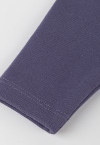 Lila Baumwollstoff mit einer glatten, leicht dehnbaren Textur; verfügt über einen sauberen Rand und einen ordentlich genähten Saum.