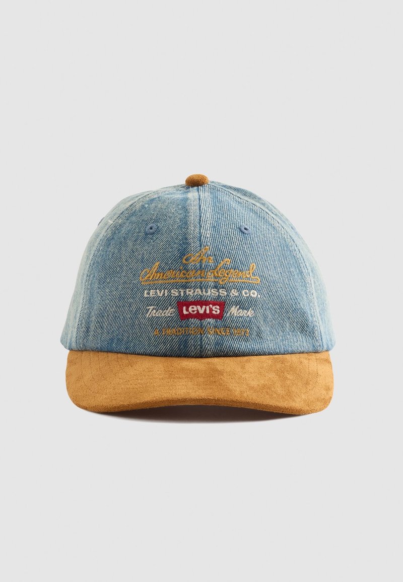 Casquette de baseball en denim avec une visière en daim marron, logo Levi's brodé et texte jaune et blanc indiquant "An American Legend" et "A Tradition Since 1873."