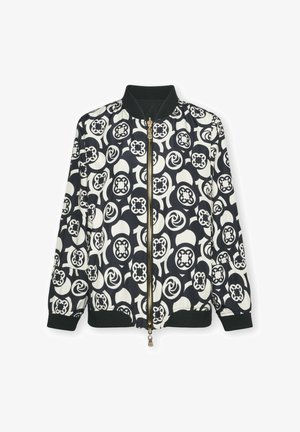Blouson aviateur noir et blanc avec des motifs circulaires audacieux, fermeture éclair, poignets côtelés et une texture lisse et brillante.