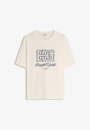T-shirt en coton couleur crème à manches courtes, arborant un design de quadrillage bleu marine et le texte : "Bright Guild" au-dessus et "WITH TIMELESS PUNCH" en dessous.
