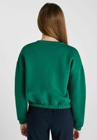 Groene sweatshirt met een ontspannen pasvorm, geribde halslijn en tailleband, en lange mouwen; gemaakt van zachte, textuurstof.