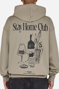 Kaki hettegenser med en stor svart grafikk som viser briller, flasker og blomster. Teksten "Stay Home Club" står over designet.