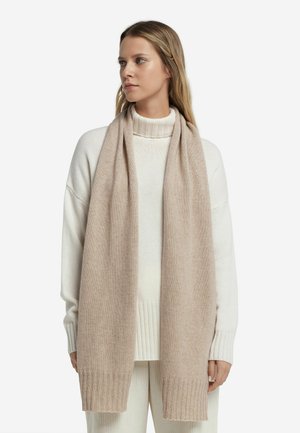 Beige knit scarf made from soft wool, featuring a smooth texture and ribbed edges, worn over a white turtleneck sweater.
