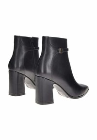 Stivali ankle in pelle nera con punta arrotondata e tacco a blocco alto e strutturato. Presentano una cerniera laterale e un dettaglio decorativo con cintura.