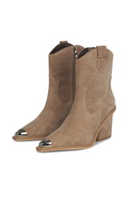 Botas de ante marrón hasta el tobillo con punta afilada, detalle de capuchón metálico y tacón de bloque de altura media. Cuenta con una cremallera lateral para facilitar su uso.