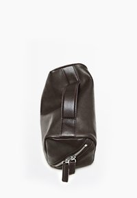 Bruine leren tas met een rechthoekige vorm, afgeronde hoeken, een handvat aan de bovenkant en een zilveren ritsluiting aan de zijkant. Gladde textuur.