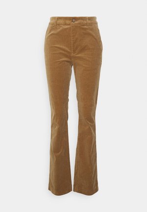 Ruskeat corduroy-housut, joissa on korkea vyötärö, napillinen suljenta, vyölenkit ja liehuvat lahkeet.