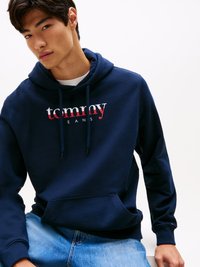 Felpa blu navy realizzata in tessuto morbido, caratterizzata da un logo "tommy jeans" bianco e rosso, con cappuccio, lacci e tasca frontale. Design casual con polsini a coste.