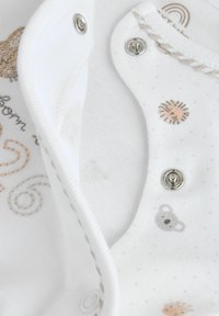 Wit katoenen romper met diermotieven in zachte kleuren, drukknoopsluitingen en decoratieve stiksel langs de randen.