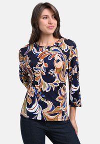 Navy floral print top with three-quarter sleeves, featuring vibrant colors like orange, green, and beige, made from a smooth, lightweight fabric.