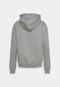 Sudadera con capucha gris, fabricada en un tejido suave. Presenta un corte relajado, mangas largas y una capucha redondeada sin herrajes visibles.