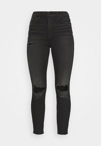 Svarta smala jeans i denim, med slitna knäskärningar, hög midja och klassisk 5-fickdesign. Slät textur, figurnära.