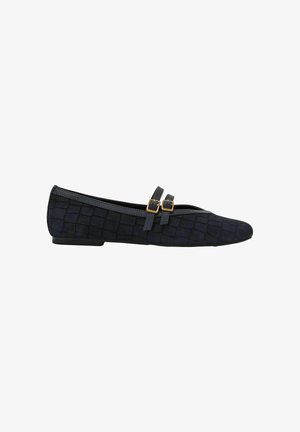 Scarpa piatta nera con motivo testurizzato, due cinturini laterali con fibbie dorate e punta appuntita, mostrata di profilo su sfondo bianco.