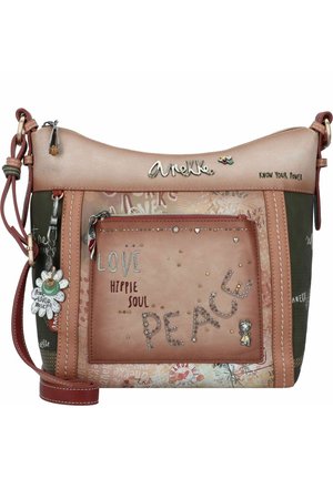 Mehrfarbige Handtasche aus einer Mischung aus zartem Pink und dunkelgrünem Leder, mit dekorativem Nähen, geprägtem Text und einem Blumenanhänger.